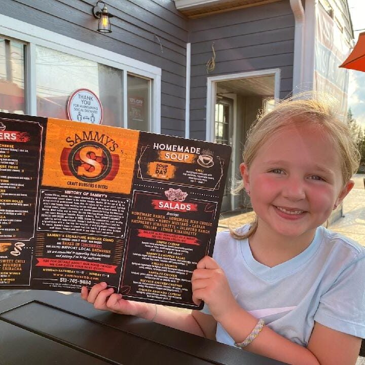 Happy girl holding Sammy's menu